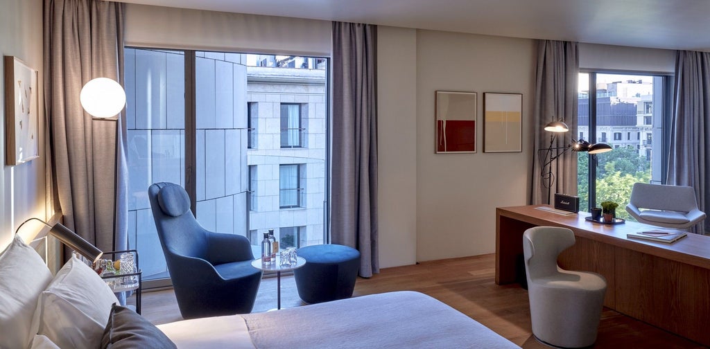 Elegant modern hotel room at Sir Victor with minimalist design, warm wood tones, floor-to-ceiling windows overlooking Barcelona's urban landscape