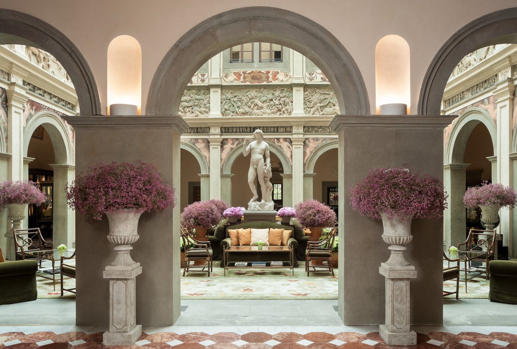 Ornate Renaissance-style luxury hotel with manicured Italian gardens, stone fountains and classical architecture in Florence's city center