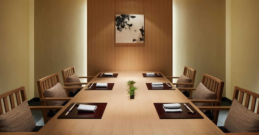 Modern luxury hotel lobby with grand marble staircase, ambient lighting, and minimalist Japanese design featuring wooden elements