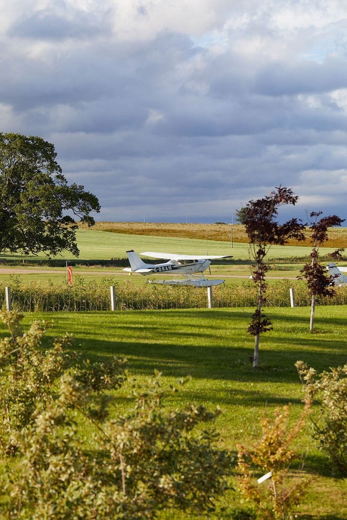 Luxurious stone manor hotel nestled in lush Scottish countryside, featuring elegant architectural details and pristine landscaped gardens at dusk