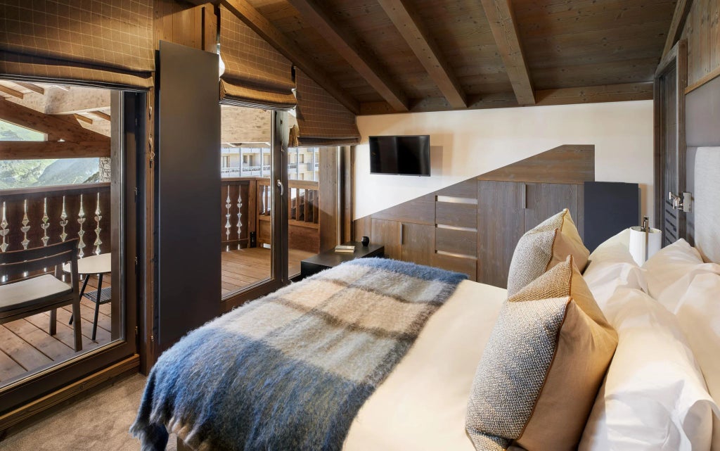 Luxurious alpine ski chalet interior with panoramic mountain views, elegant contemporary furnishings, and warm wood accents in Courchevel, France