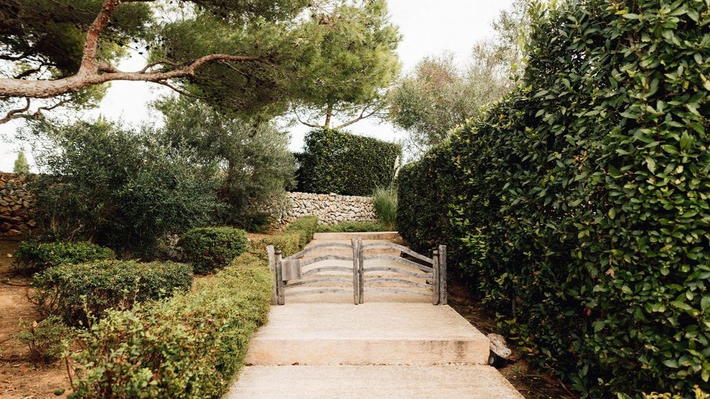 Elegant whitewashed garden cottage with stone walls, lavender accents, and rustic Mediterranean charm nestled in scenic Spanish countryside landscape