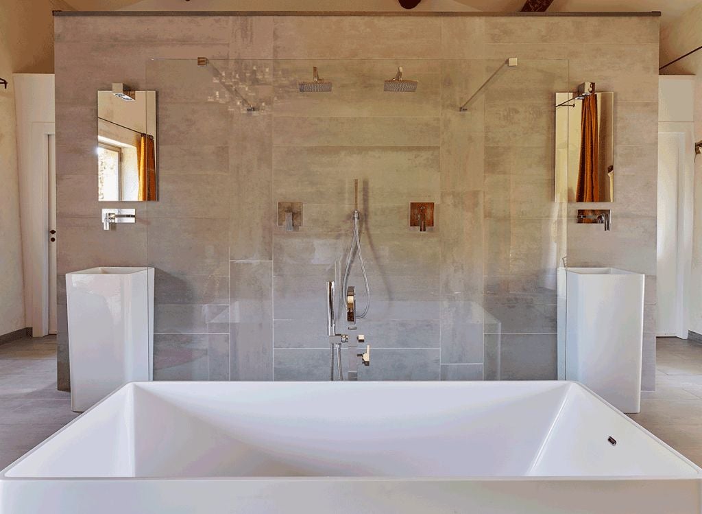 Elegant stone-walled suite with luxurious white bed, vintage furnishings, and soft natural light in a charming French countryside hotel room