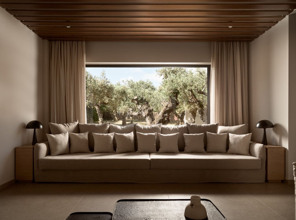 Luxurious white-washed Greek villa bedroom with panoramic sea view, minimalist design, and elegant wooden furniture against blue Aegean backdrop