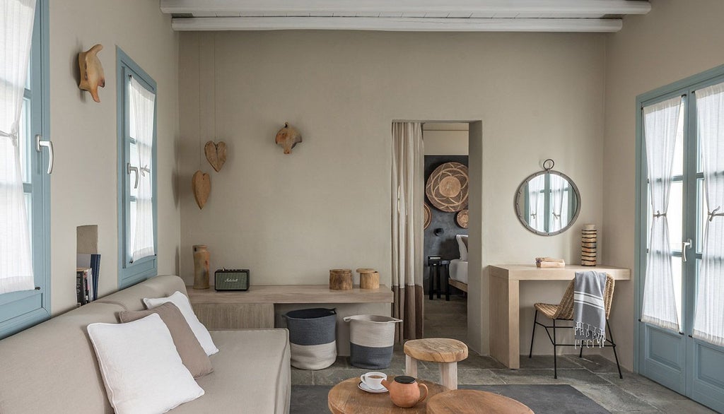 Luxurious white-washed Greek hotel room with minimalist design, plush bedding, and panoramic Aegean Sea view from private balcony at Verina Astra resort, Sifnos.