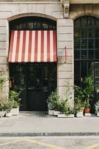 Elegant terracotta-hued boutique hotel with modernist design, featuring lush indoor plants and sun-drenched Barcelona architectural charm