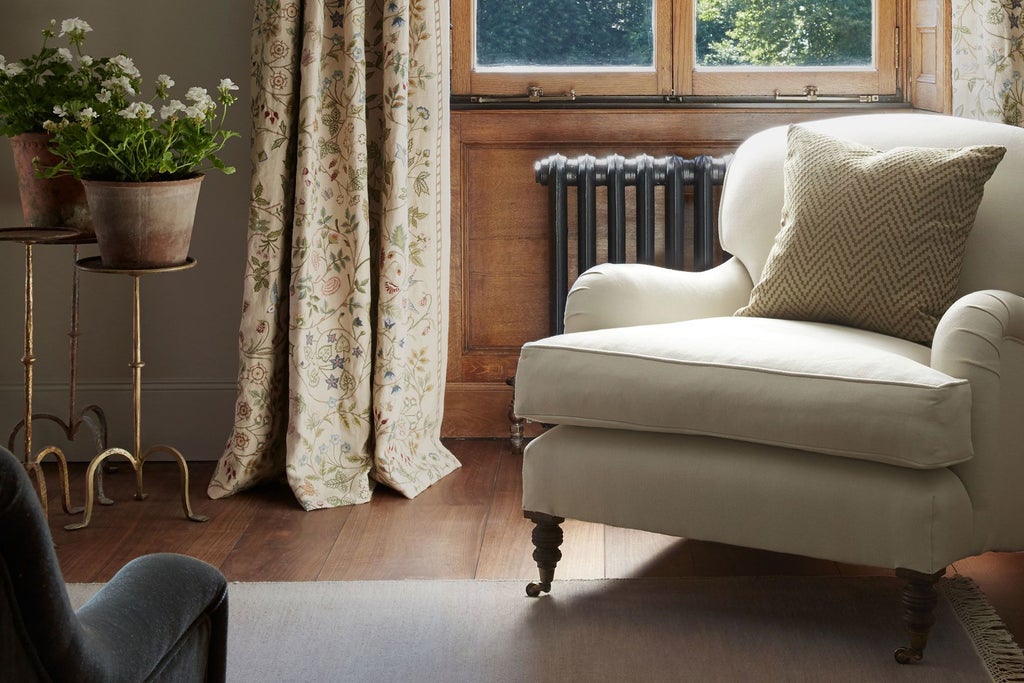 Elegant four-poster bed in soft neutral tones, plush textiles, and large windows overlooking verdant English countryside at Scenset luxury retreat