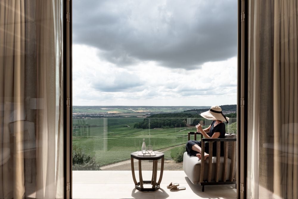 Elegant suite with panoramic vineyard views, featuring a king bed, freestanding bathtub, and contemporary French design accents