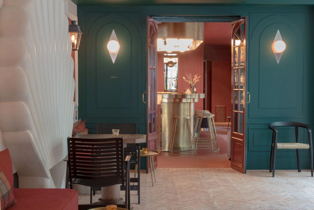 Elegant Parisian hotel interior with ornate chandeliers, plush velvet seating, and rich historical decor reflecting 19th-century French architectural grandeur.