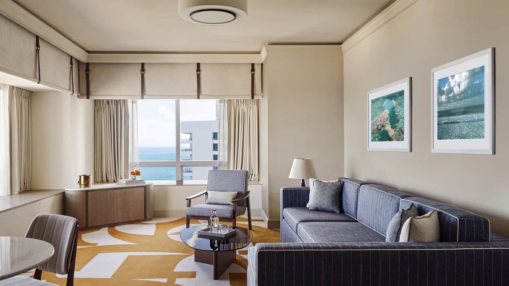 Luxurious corner suite with panoramic bay views, modern decor, king bed, floor-to-ceiling windows, and elegant seating area at Four Seasons Hotel Miami