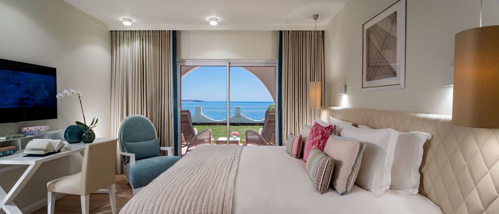 Elegant deluxe hotel room with panoramic ocean view, featuring modern Portuguese design, plush white bedding, and expansive blue Atlantic horizon