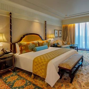 Elegant executive suite at scenset Palace with rich wooden furnishings, plush king bed, panoramic city view, and sophisticated contemporary Indian design aesthetic