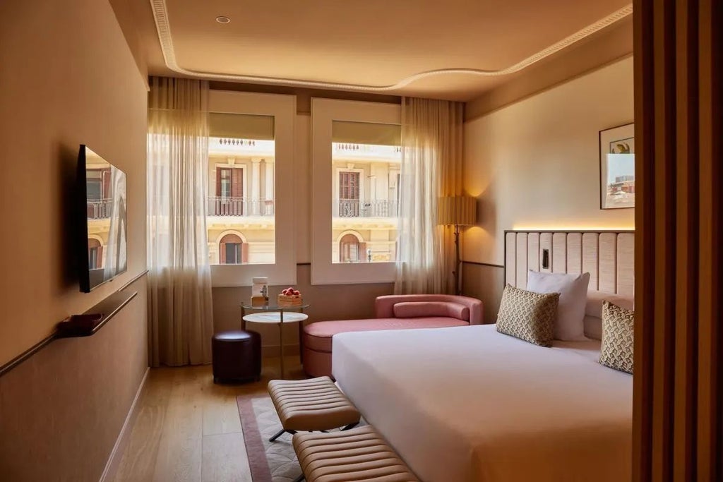 Elegant superior room at Grand Hotel Central, featuring plush white bedding, modern minimalist decor, and expansive city view through large window in Barcelona