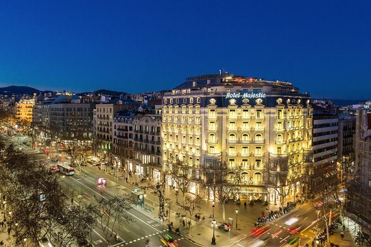 Elegant white façade of Majestic Hotel Barcelona with ornate balconies, classical architecture, and palm trees along Passeig de Gràcia