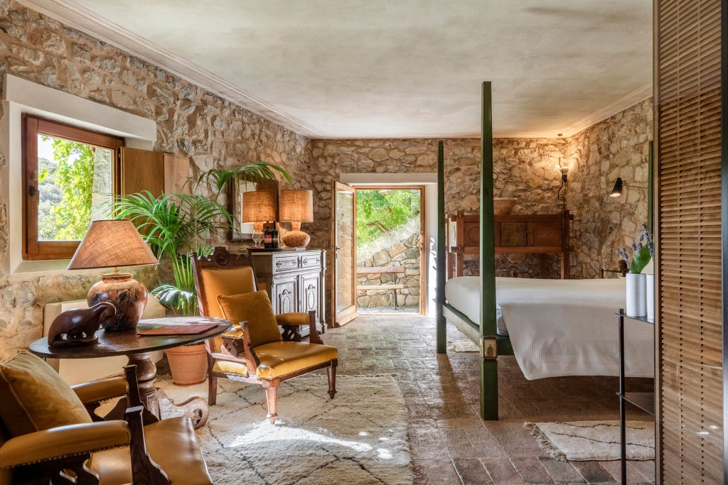 Elegant Tuscan-style luxury suite with stone walls, plush king bed, ornate wooden furniture, and panoramic views of rolling Italian countryside hills