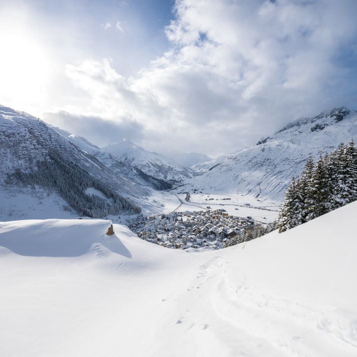 Luxurious alpine hotel with modern minimalist design, snow-capped mountains, contemporary wooden interiors, and elegant Swiss mountain landscape backdrop