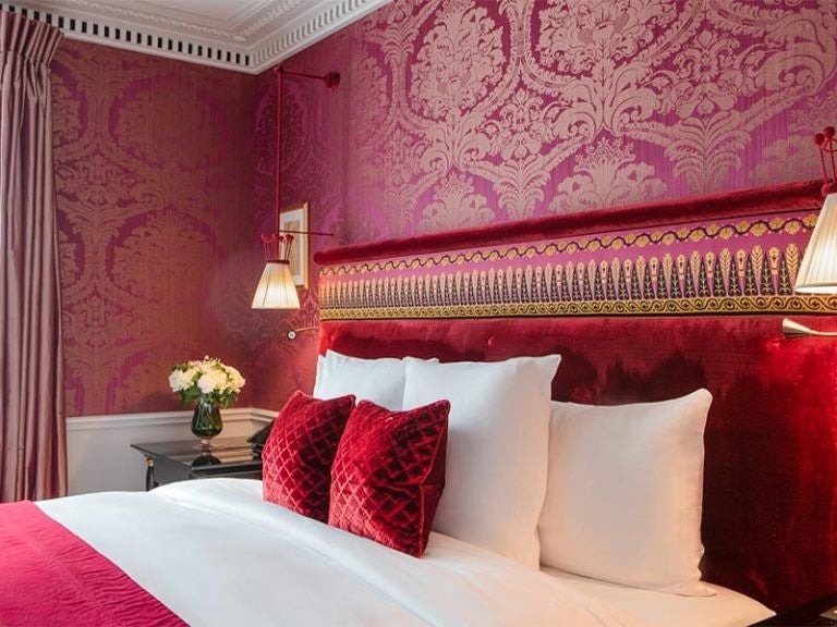 Opulent Parisian prestige suite with antique furnishings, silk damask walls, crystal chandelier, and views overlooking the Grand Palais gardens