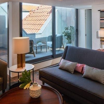 Luxurious studio suite with minimalist design, soft neutral tones, modern furnishings, and large windows overlooking scenic Portuguese landscape at The Lumiares Hotel & Spa