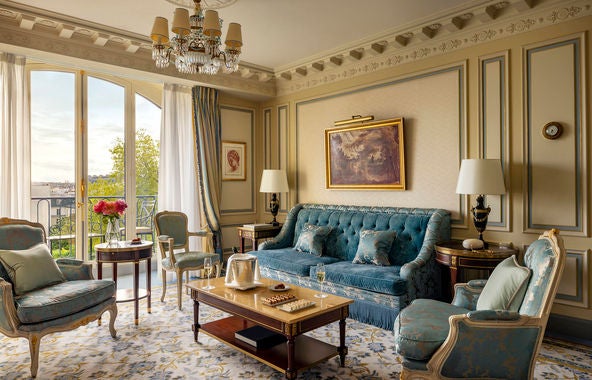 Luxurious Executive Suite at Ritz Paris featuring ornate gold décor, crystal chandelier, silk drapes and period furniture in cream tones