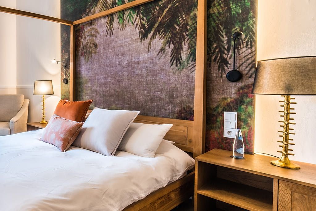 Elegant double garden room at L'Avenida Sóller, featuring plush white bedding, warm wood accents, and soft natural light from Spanish villa windows