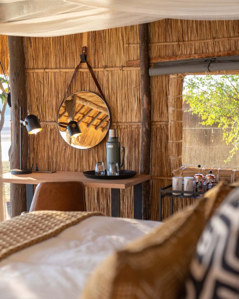 Luxurious safari tented camp nestled along the Luangwa River, with canvas suites overlooking pristine wilderness and golden African landscape at sunset