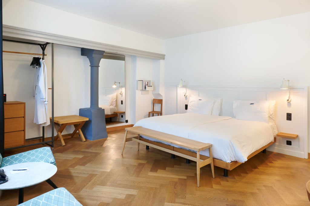 Historic double room at Marktgasse Hotel, featuring elegant Swiss decor with plush bedding, antique wooden furnishings, and soft ambient lighting in neutral tones.