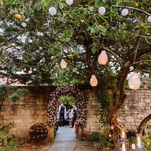 Elegant Georgian-era curved stone facade of luxurious boutique hotel with pristine white columns and manicured gardens in Bath, United Kingdom