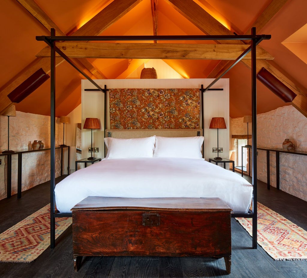 Luxurious rustic-chic bedroom at Grove of Narberth, featuring plush white bedding, exposed wooden beams, and soft neutral tones with elegant countryside charm