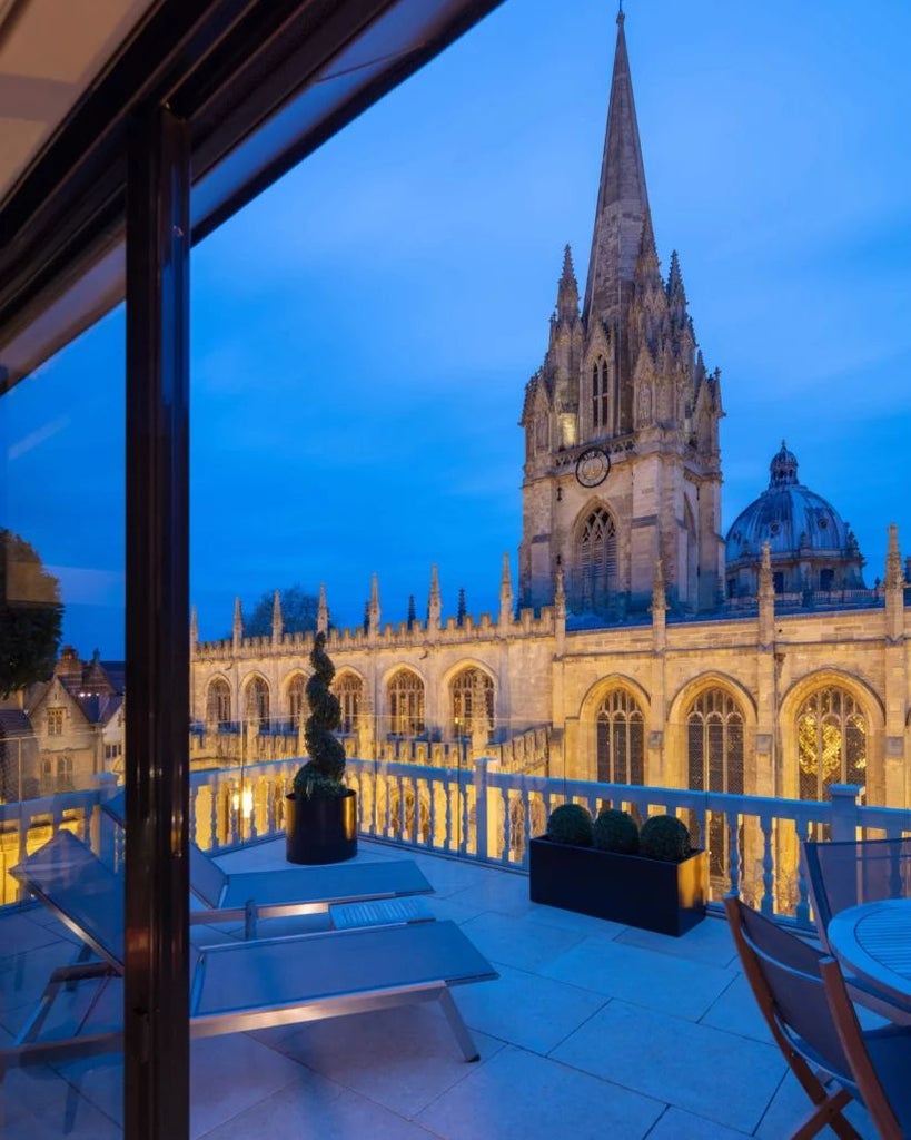 Elegant hotel room with period furnishings, large windows overlooking historic scenset architecture, blending vintage charm and luxurious contemporary comfort at Old Bank Hotel