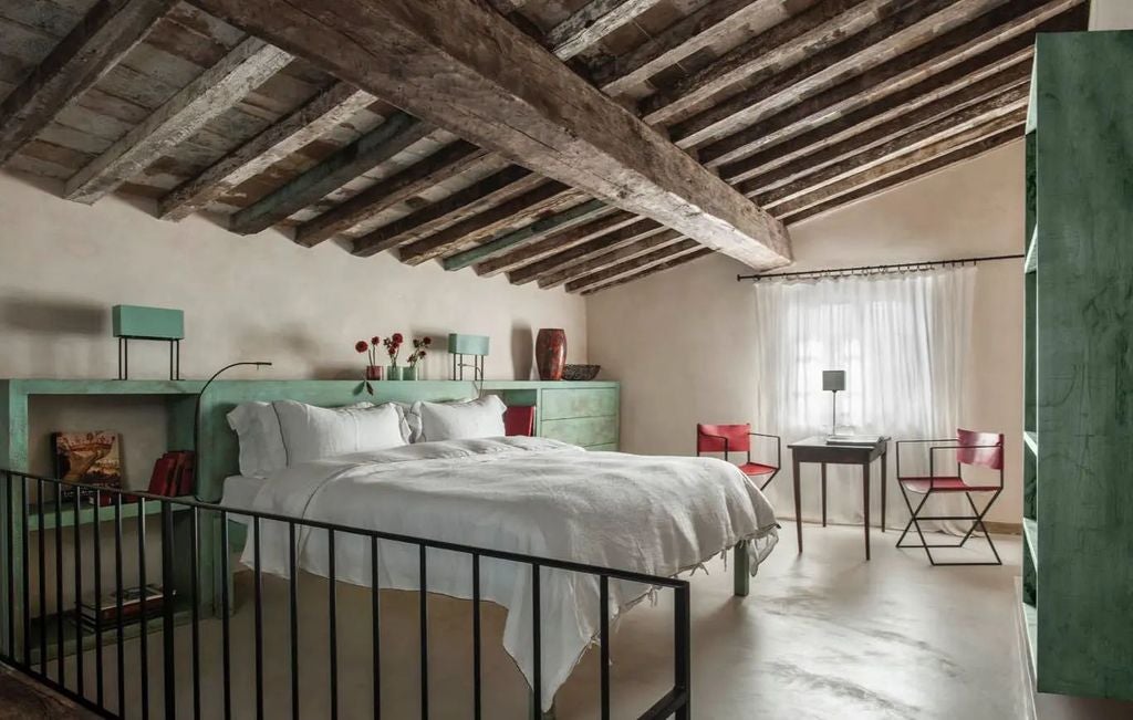 Elegant stone hotel nestled in Tuscan hillside with panoramic valley views, rustic balconies and traditional terracotta roofing