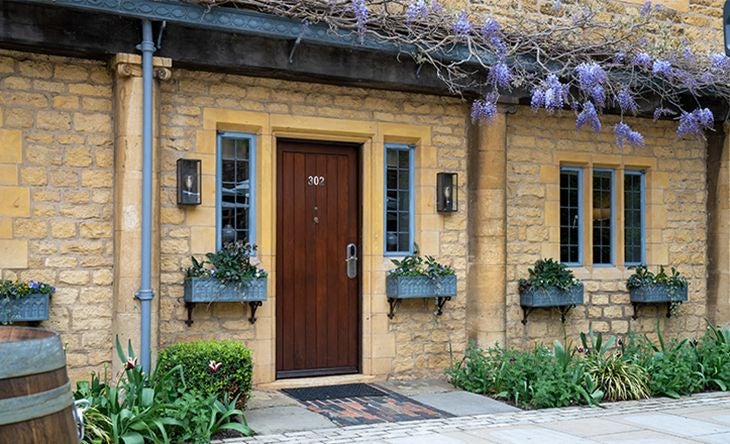 Elegant courtyard classic room at The Lygon Arms, featuring traditional British decor, plush furnishings, soft neutral tones, and timeless architectural details.