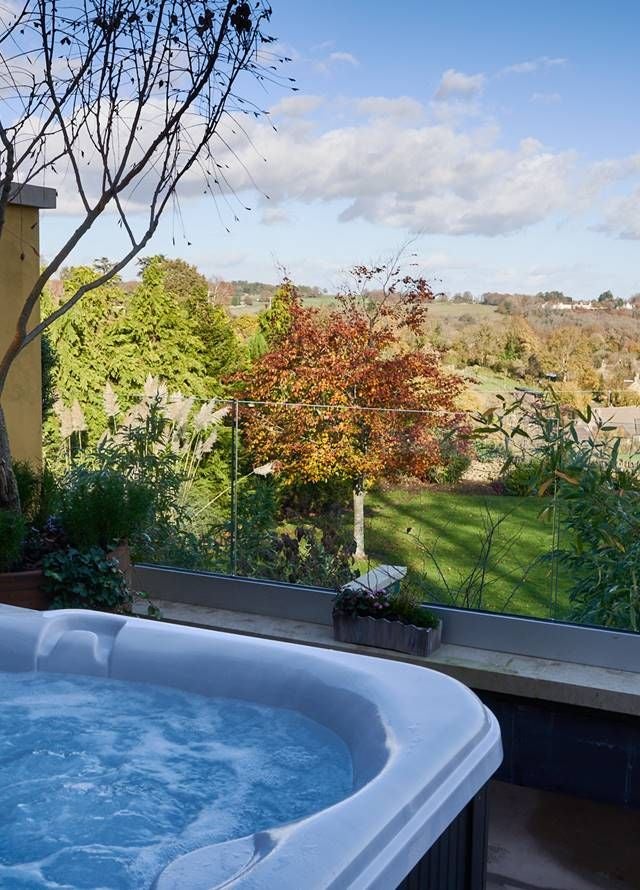 Luxurious hot tub suite at Homewood Hotel & Spa, featuring elegant white marble walls, modern design, and plush seating with soft ambient lighting