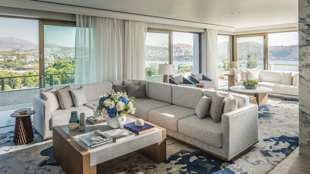 Luxurious seaside suite in Athens with floor-to-ceiling windows, modern decor, king bed, and stunning Mediterranean Sea views