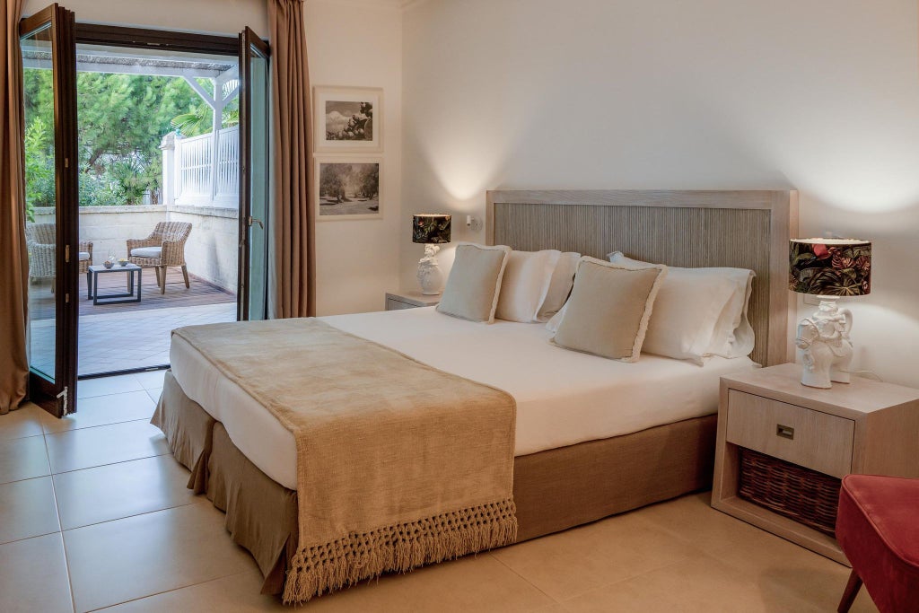 Elegant white-themed hotel room with minimalist design, crisp linens, modern furnishings, and soft natural light in a luxurious Italian coastal setting