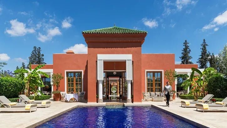 Luxurious Moroccan Royal Villa suite with expansive private pool, traditional Arabic architectural details, and elegant marble interiors at sunset.