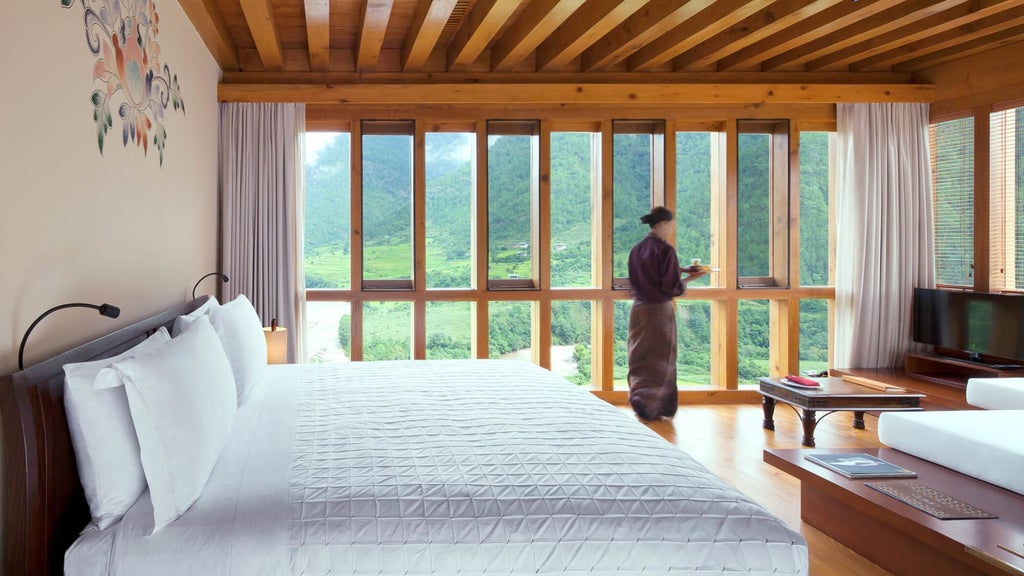 Luxurious wooden-paneled valley room with panoramic mountain views, traditional Bhutanese design, and elegant minimalist furnishings at COMO Uma Punakha