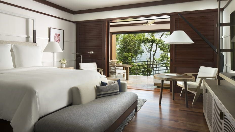 Luxurious ocean-view suite with king bed, private terrace, modern furnishings and warm wood accents overlooking Papagayo Gulf