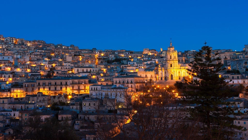 Rustic stone terrace of boutique hotel Casa Talía overlooking scenic Sicilian landscape with traditional architecture and lavender-lined stone pathway