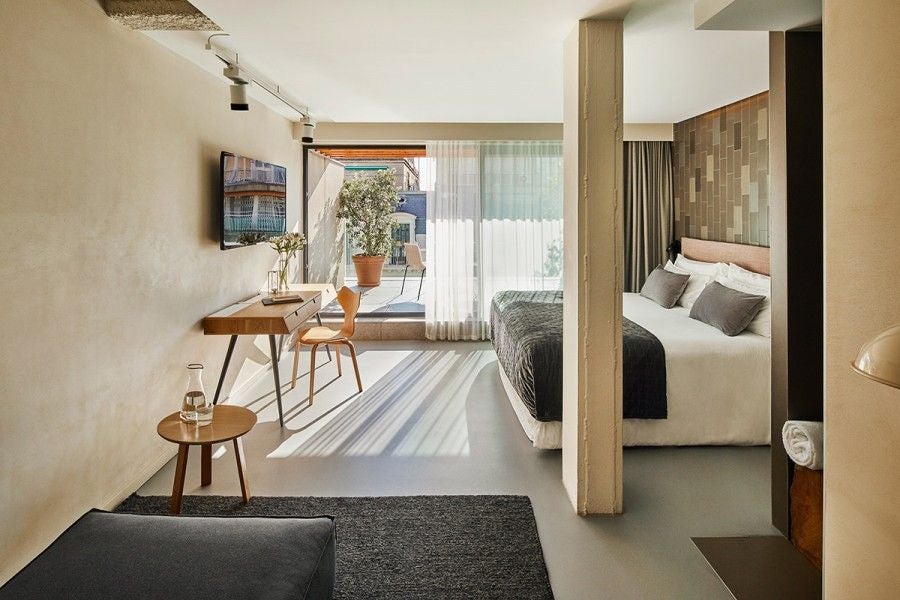 Sleek modern superior room at Scenset Eixample hotel, featuring minimalist design, crisp white linens, and elegant contemporary furnishings with soft neutral tones