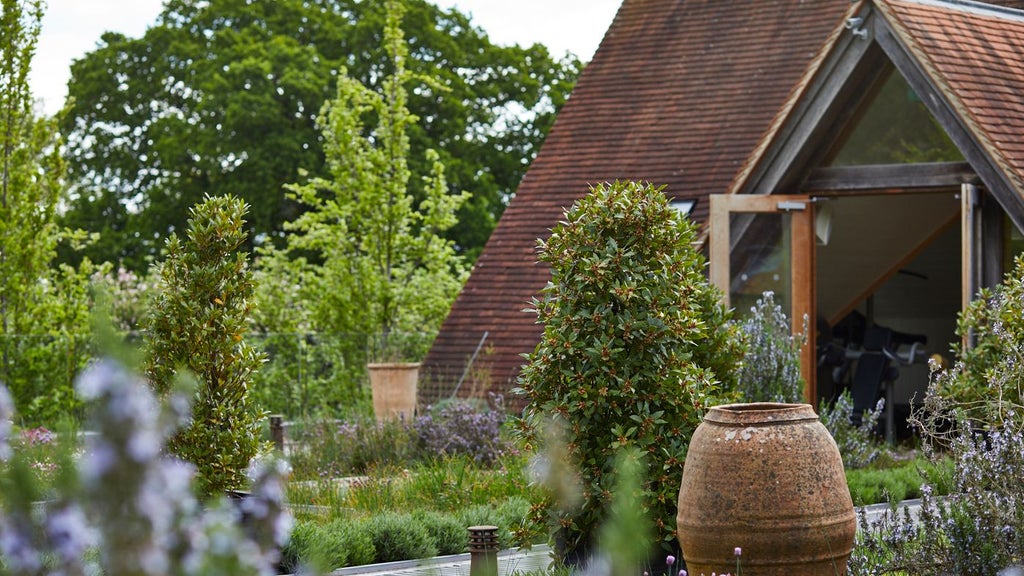 Luxurious countryside hotel nestled in New Forest, UK, featuring rustic stone exterior, lush green surroundings, and elegant architectural design with warm lighting