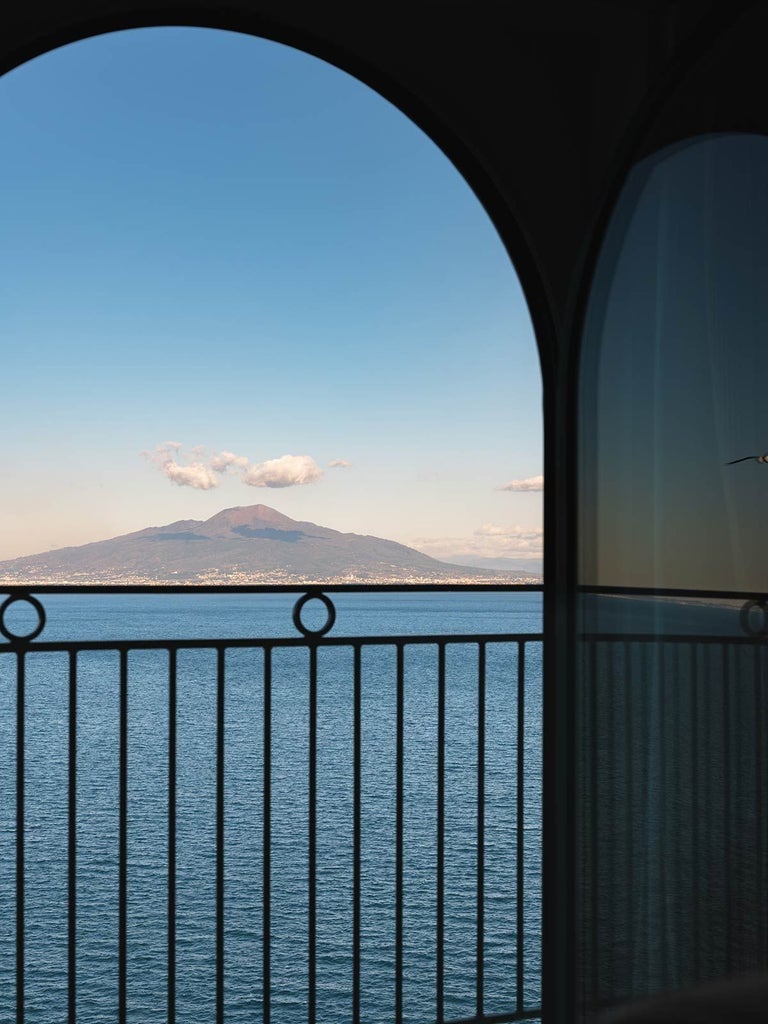 Lavish seaside suite with panoramic views of the Amalfi Coast, marble floors, ornate furnishings, and a sweeping terrace overlooking the azure Mediterranean waters