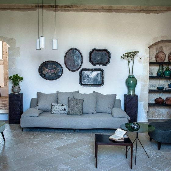 Historic Italian villa with stone archways and climbing vines, featuring elegant outdoor seating beneath rustic wooden beams at sunset