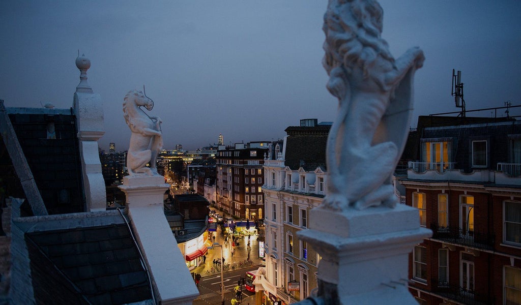 Luxurious boutique hotel facade with ornate Victorian architecture, elegant white exterior, and charming street view in London's sophisticated design district