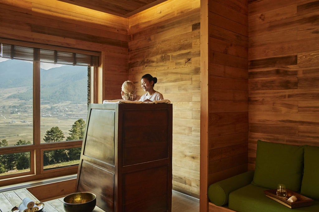 Luxury mountain lodge with floor-to-ceiling windows overlooking Bhutanese valley, featuring timber facade and private viewing deck