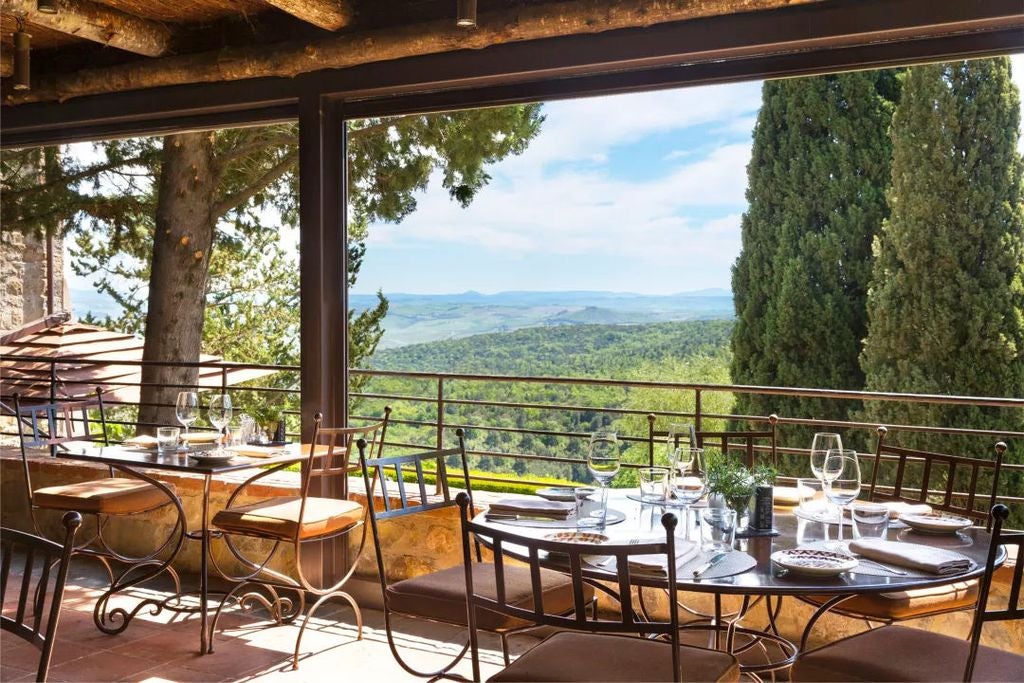 Elegant Italian villa hotel nestled in Tuscan hills, featuring stone facade, terracotta roof and manicured gardens with cypress trees