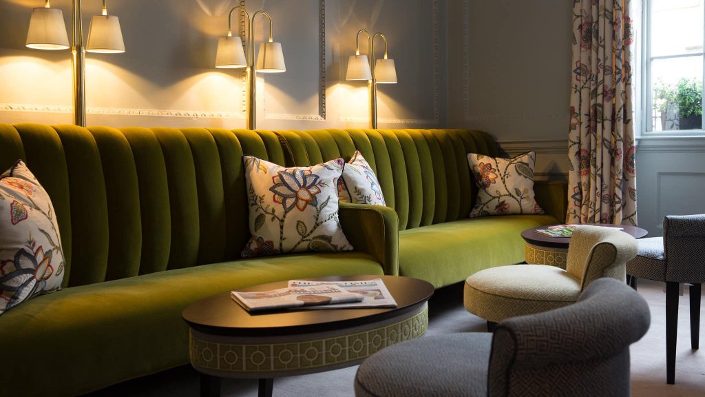 Elegant boutique hotel facade with Georgian-style architecture, warm limestone exterior, and classic sash windows in a charming urban setting in United Kingdom.