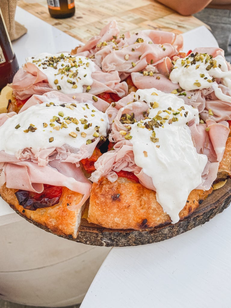 Two wine glasses and bruschetta on rustic wooden table at elegant Tuscan restaurant overlooking Florence's historic skyline