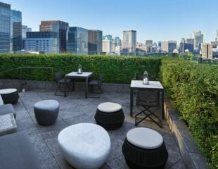 Elegant Tokyo luxury hotel exterior with modern architectural design, sleek glass facade, and pristine landscaped entrance reflecting Japanese minimalist sophistication