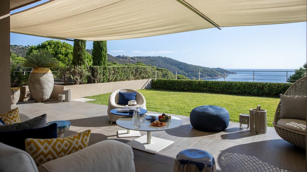 Luxurious beachfront villa at La Réserve Ramatuelle, nestled among pine trees with panoramic Mediterranean coastline views and modern architectural design.