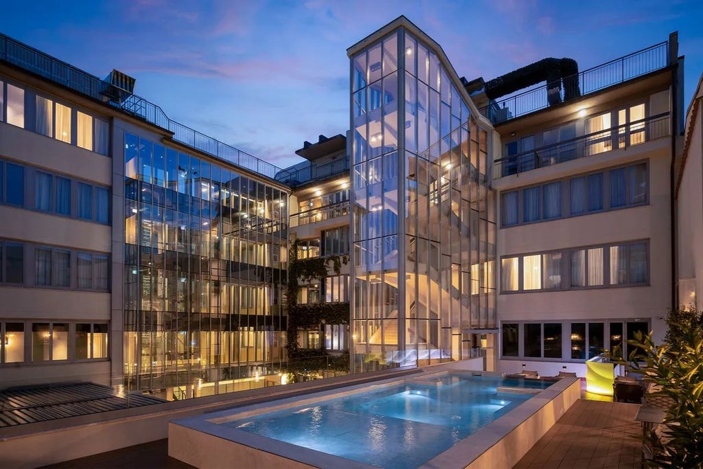 Contemporary luxury hotel facade in Florence, featuring modern architectural design with sleek glass windows and elegant minimalist exterior in soft neutral tones